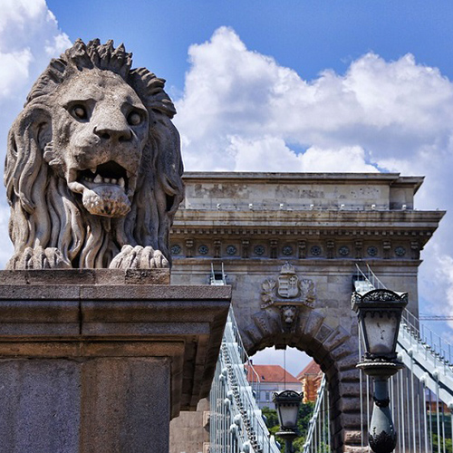 Statue d'un lion au début d'un pont 
