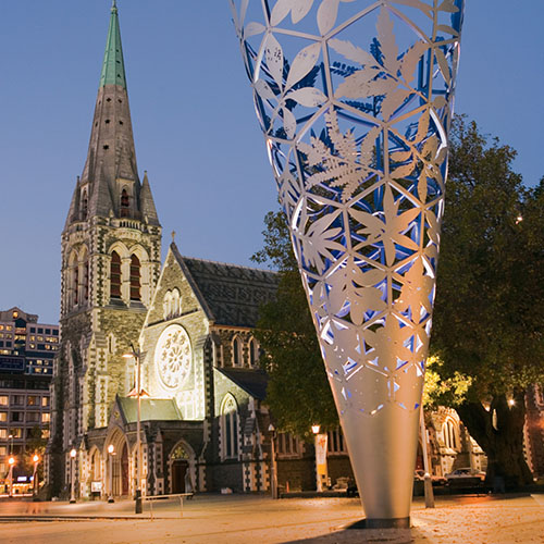 Cathédrale  illuminée de style néo-gothique contrastant avec la sculpture moderne