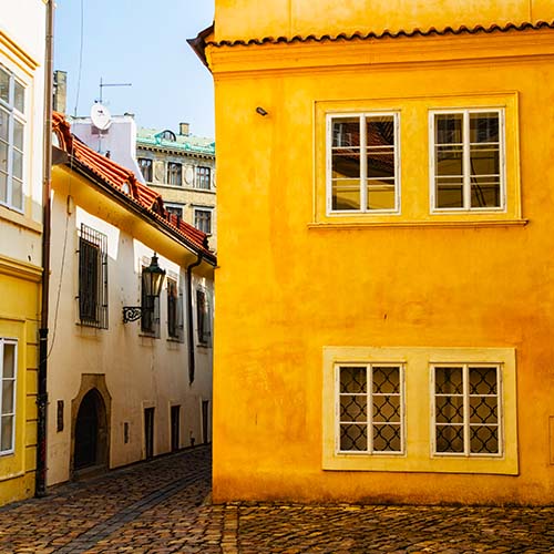 Typique ruelle en dalles avec sur le coin une maison jaune étincellant